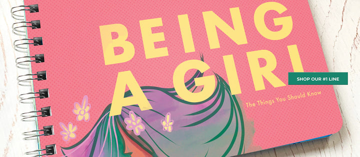 Being a Girl book from Papersalt on wood background as an intro to Papersalt's inspirational book collection for kids, teens and families